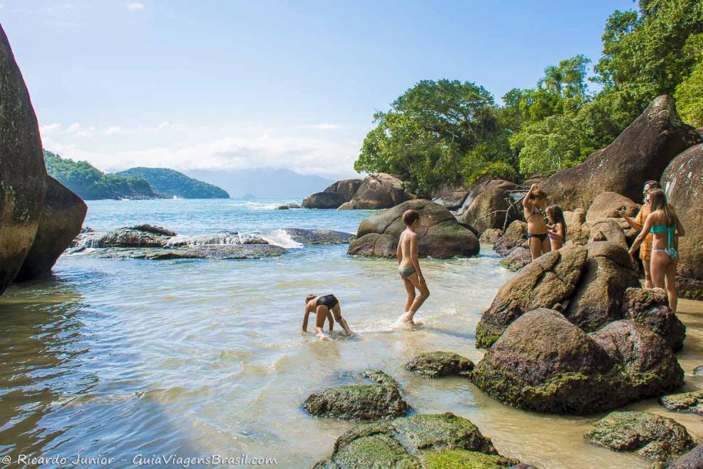 Imagem de crianças nas pedras da Praia do Félix.